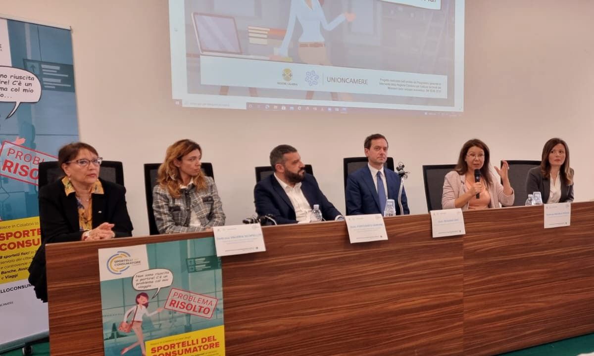 Foto della conferenza con i partecipanti schierati dietro al tavolo