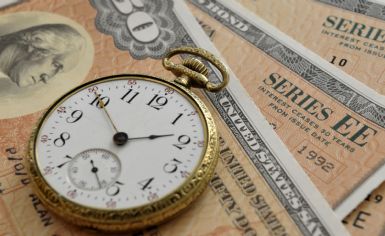 Foto di un orologio da taschino poggiato su un mazzo di cedole